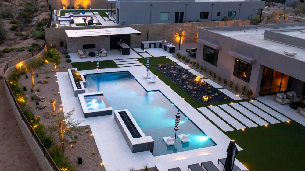 Aerial view of a modern Arizona backyard pool with integrated spa and outdoor living space
